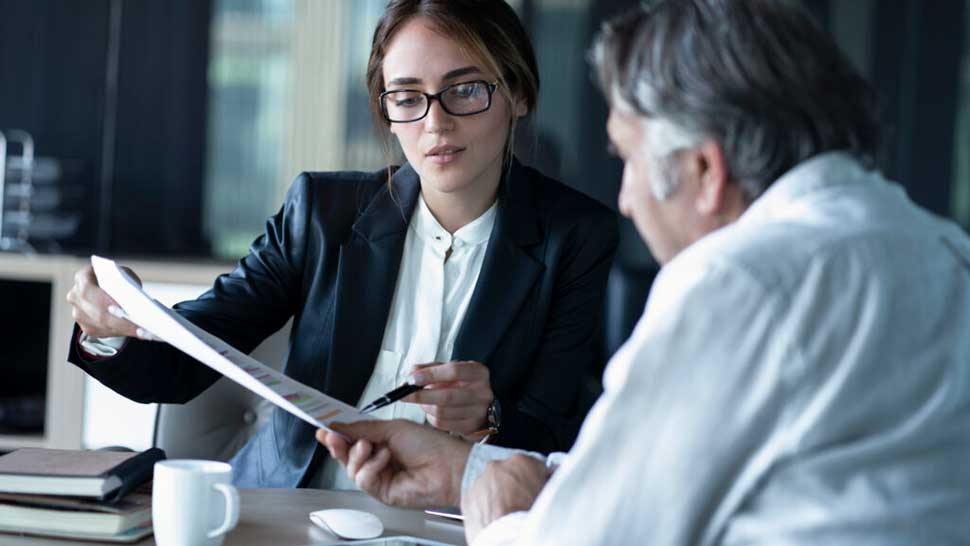 Man and woman in meeting reviewing document